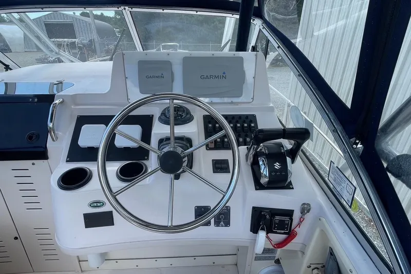 Slide: The Image of 2001 Grady-White Sailfish 255 boat helm with Garmin navigation and Suzuki controls. - 9