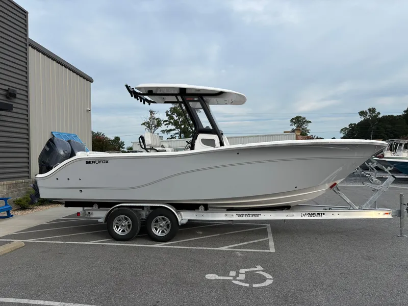 Slide: The Image of 2025 Sea Fox 268 Commander boat on trailer, parked in a lot near a building. - 3