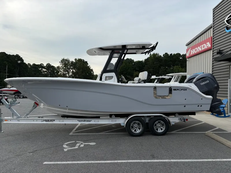 Slide: The Image of 2025 Sea Fox 268 Commander boat on trailer, parked near dealership. - 6