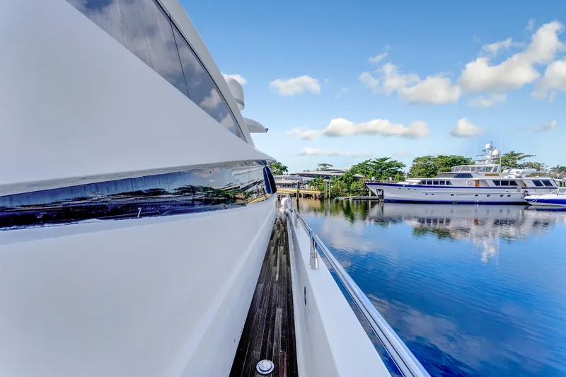 Slide: The Image of 2007 Sunseeker Predator 108 yacht docked, reflecting on calm water under blue sky. - 37
