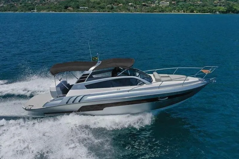 The Image of 2025 Hanover 305 Inboard boat cruising on blue ocean with scenic mountain backdrop. - 1