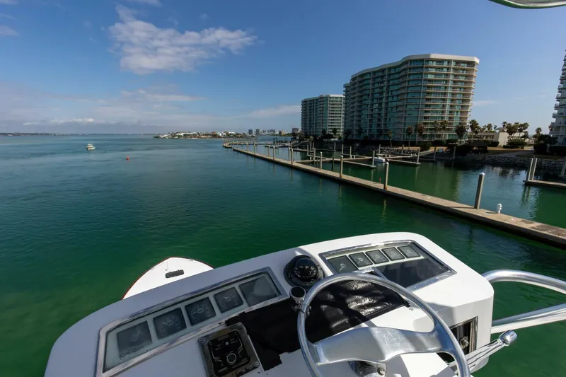 Slide: The Image of Custom Ebony Sportfish 65' CNV 2004 yacht overlooking marina and waterfront buildings. - 28