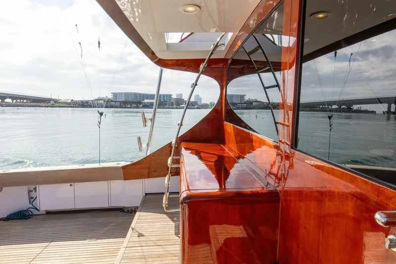 Slide: The Image of Custom Ebony Sportfish 65' CNV yacht, 2004, with polished wood finish, docked by the water. - 38