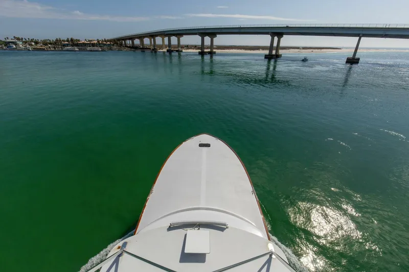 Slide: The Image of Bow view of 2004 Custom Ebony Sportfish 65' CNV approaching a bridge over calm green waters. - 48