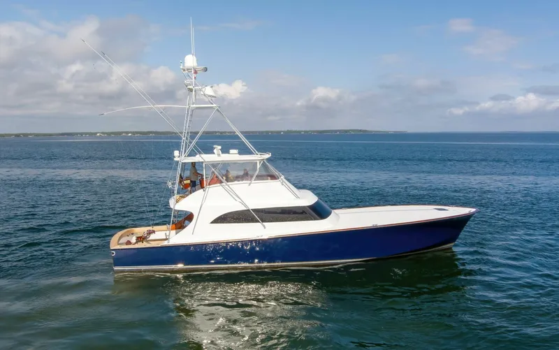 Slide: The Image of Custom Ebony Sportfish 65 Convertible yacht, 2004 model, cruising on open water under a clear sky. - 49