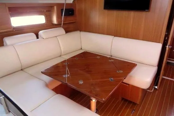 Slide: The Image of Interior of 2016 Catalina 445 yacht with white seating and wooden table. - 13