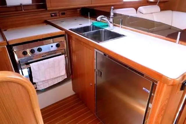 Slide: The Image of 2016 Catalina 445 yacht kitchen with stainless steel appliances and wooden cabinetry. - 25