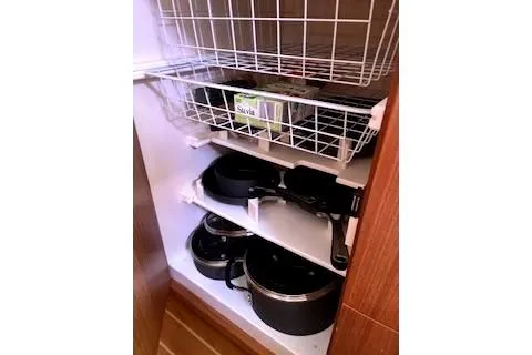 Slide: The Image of Kitchen cabinet with cookware and wire baskets in a 2016 Catalina 445. - 32