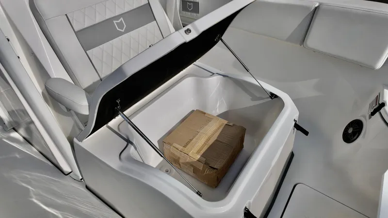 Slide: The Image of 2025 Sea Fox 268 Commander boat storage compartment with open lid and cardboard box inside. - 16