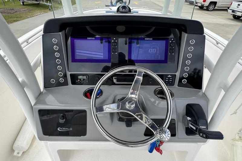 Slide: The Image of 2021 Robalo R242 Explorer boat dashboard with steering wheel and Simrad displays. - 15