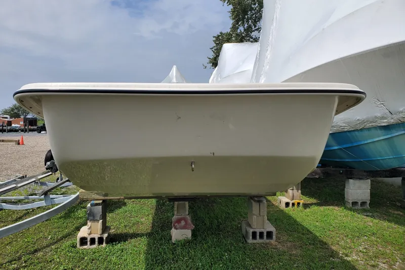 Slide: The Image of 2024 Carolina Skiff E24DLX Kit boat on blocks, front view, outdoors. - 8