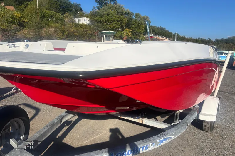 The Image of Red and white 2026 Starcraft SV 16 OB boat on a trailer, parked outdoors. - 1