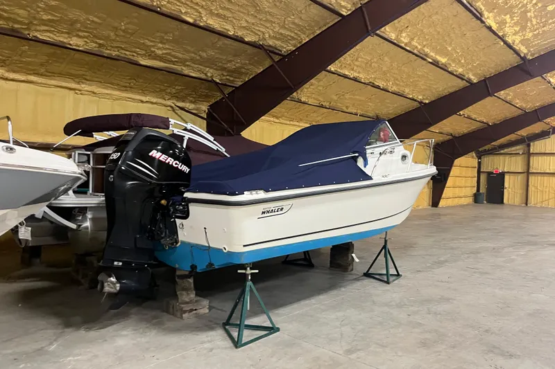 Slide: The Image of 2006 Boston Whaler 205 Conquest boat with Mercury engine in indoor storage. - 1