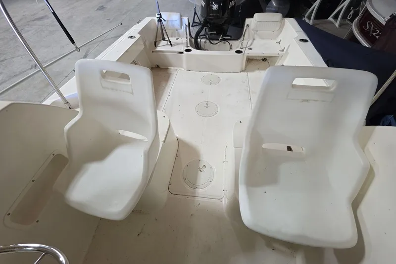Slide: The Image of 2006 Boston Whaler 205 Conquest boat interior with white seating and motor view. - 7