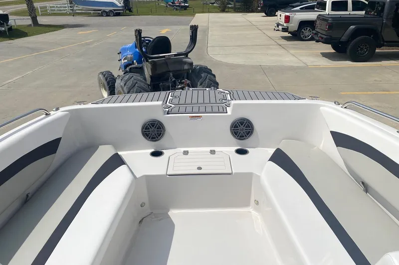 Slide: The Image of 2021 Starcraft SVX 171 OB boat interior with seating and speakers, parked near a tractor. - 4