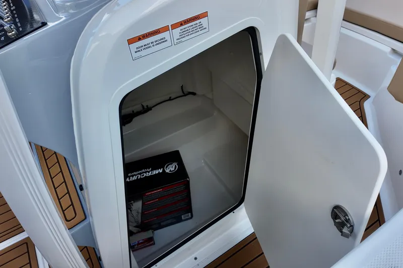 Slide: The Image of Open storage compartment on 2026 Bayliner Trophy T20CC boat with Mercury box inside. - 13
