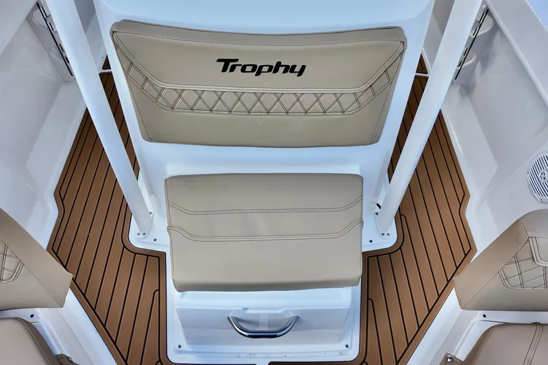 Slide: The Image of 2026 Bayliner Trophy T20CC boat interior with tan seating and wood-patterned flooring. - 15