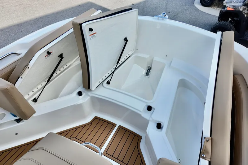 Slide: The Image of 2026 Bayliner Trophy T20CC boat interior with open storage compartments and cushioned seating. - 16