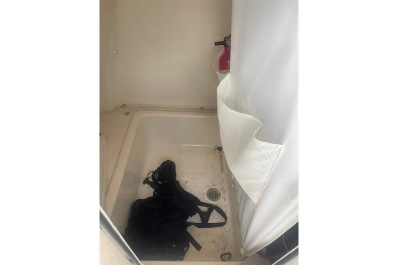 Slide: The Image of Interior of 2022 Pioneer 202 Islander boat with shower area and fire extinguisher. - 18