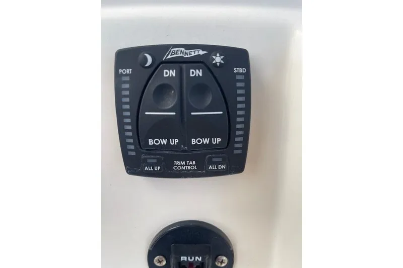 Slide: The Image of 2022 Pioneer 202 Islander trim tab control panel with Bennett switches. - 24