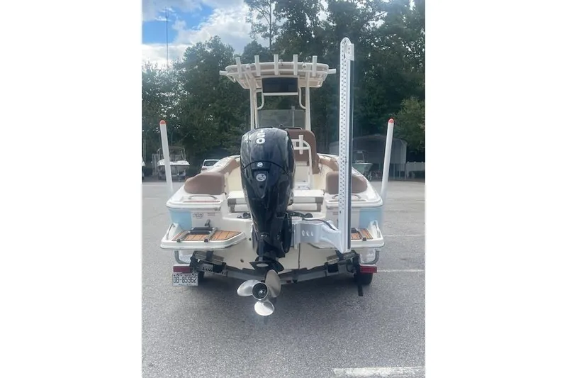 Slide: The Image of 2022 Pioneer 202 Islander boat, rear view with outboard motor, parked outdoors. - 4