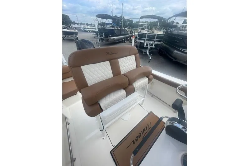 Slide: The Image of 2022 Pioneer 202 Islander boat with brown and white cushioned seating at a marina. - 8