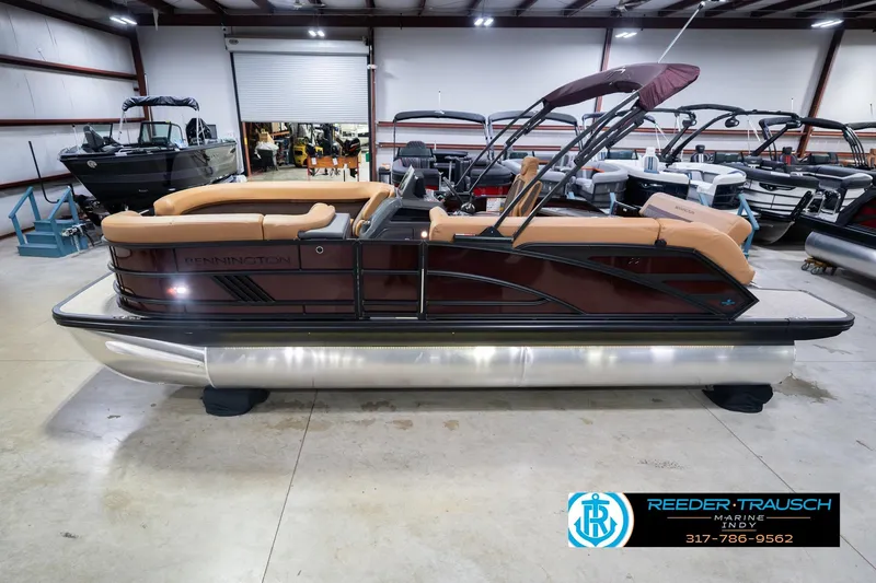 The Image of 2026 Bennington 22 ML pontoon boat in showroom, featuring tan seating and sleek design. - 0