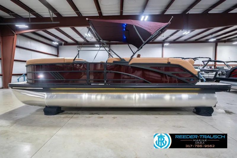 Slide: The Image of 2026 Bennington 22 ML pontoon boat in showroom with canopy and sleek design. - 11