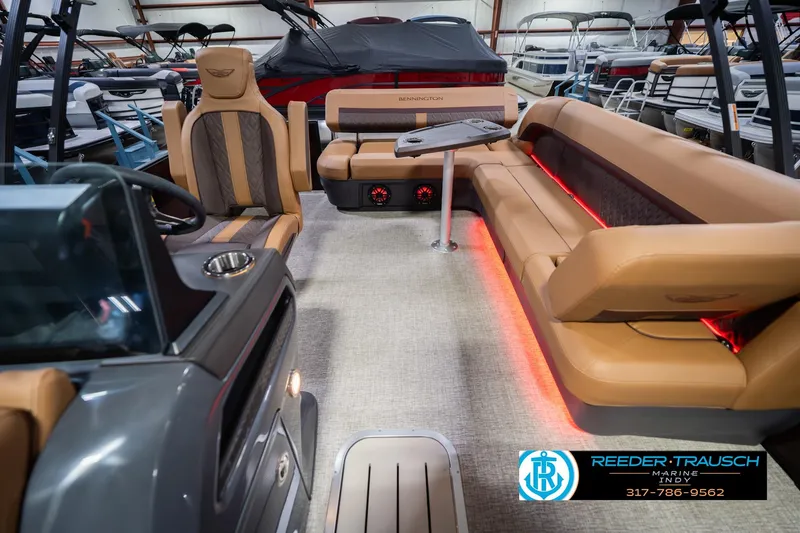 Slide: The Image of 2026 Bennington 22 ML pontoon boat interior with tan seating and ambient lighting. - 17