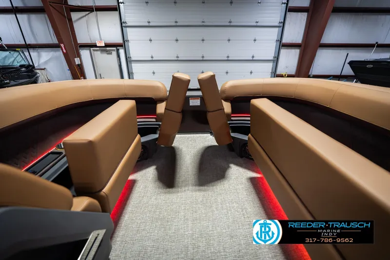 Slide: The Image of Interior of 2026 Bennington 22 ML boat with tan seating and red accent lighting. - 22