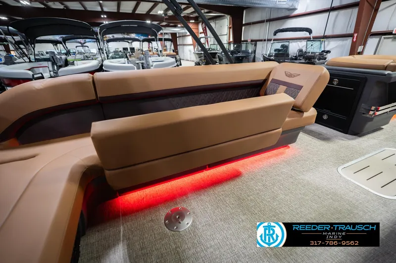 Slide: The Image of 2026 Bennington 22 ML boat interior with brown seating and red LED lighting. - 31