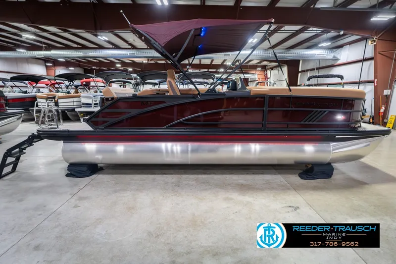 Slide: The Image of 2026 Bennington 22 ML pontoon boat in showroom with maroon canopy and sleek design. - 7