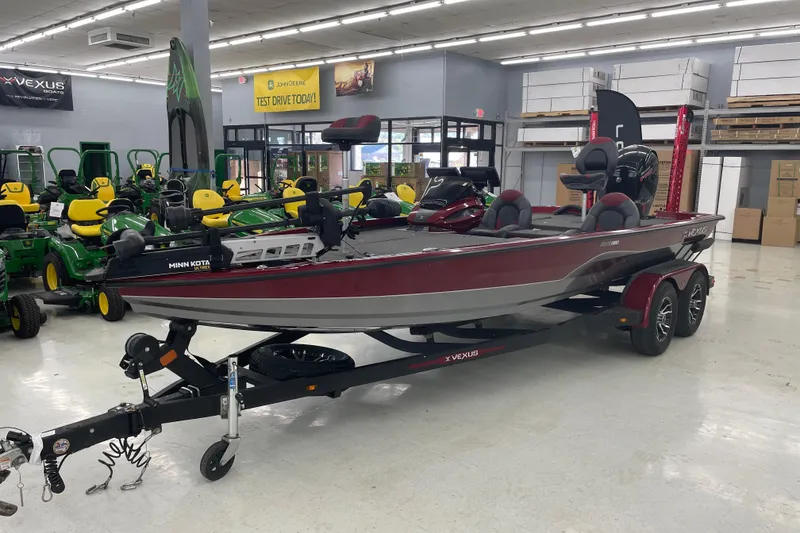 Slide: The Image of 2023 Vexus AVX1980 boat displayed indoors, surrounded by green and yellow equipment. - 1