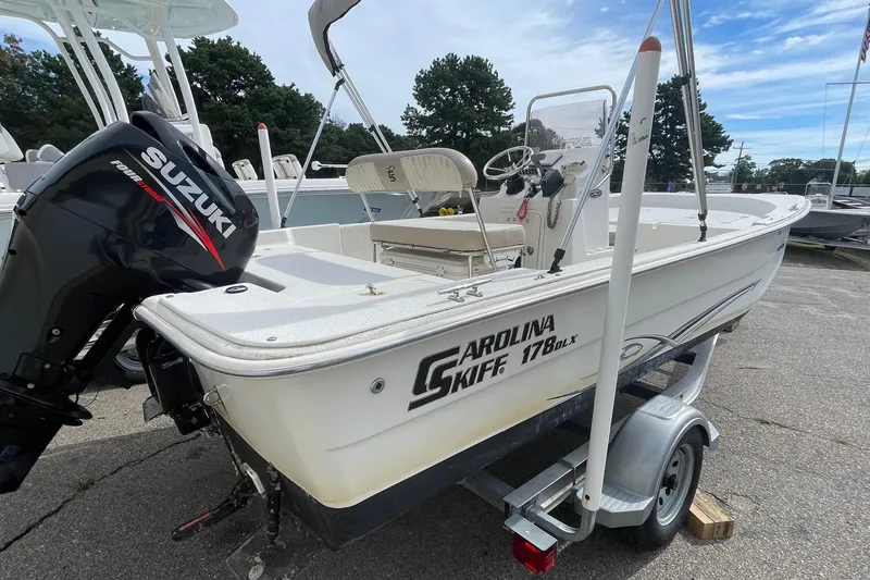 Slide: The Image of 2016 Carolina Skiff 178 DLX boat with Suzuki outboard motor on trailer. - 5