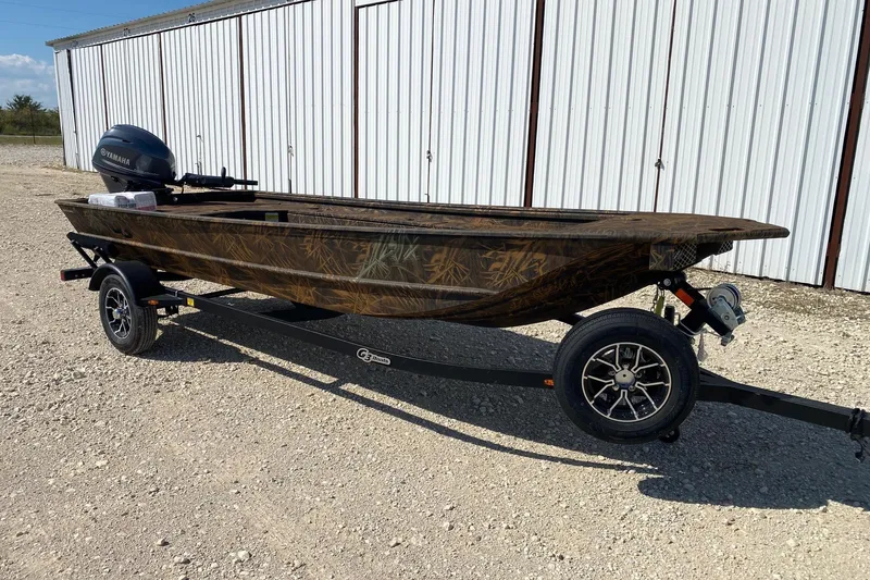 Slide: The Image of 2026 G3 16DK boat on trailer with Yamaha motor, parked on gravel near metal building. - 1