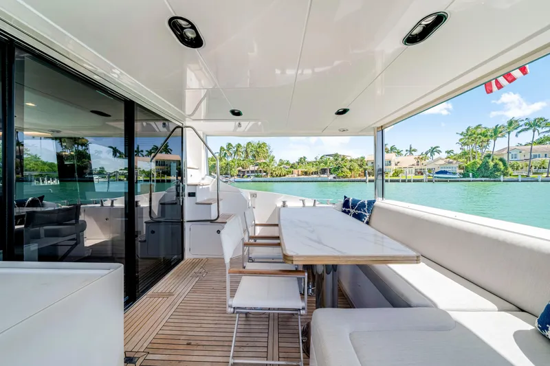 Slide: The Image of Luxurious 2020 Azimut 60 Fly yacht deck with elegant seating and scenic waterfront view. - 13