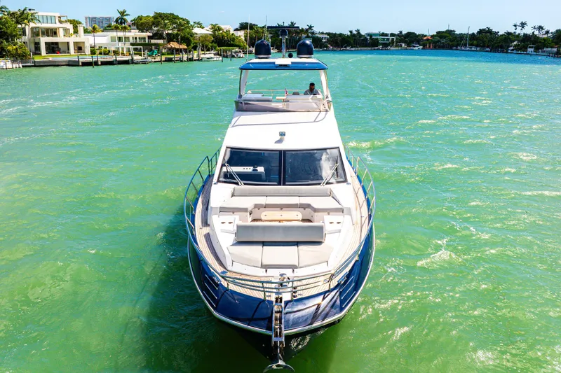 Slide: The Image of Azimut 60 Fly 2020 yacht cruising on turquoise waters near luxury waterfront homes. - 4