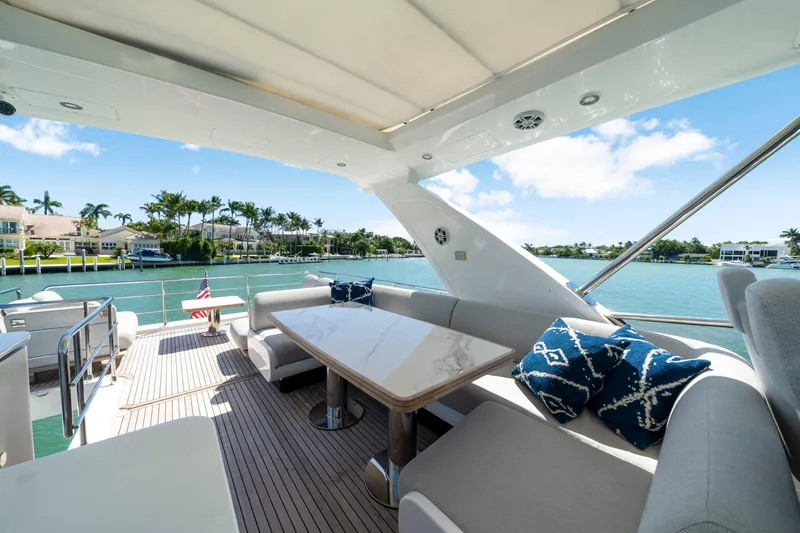 Slide: The Image of Luxurious 2020 Azimut 60 Fly yacht deck with elegant seating and scenic waterfront view. - 45