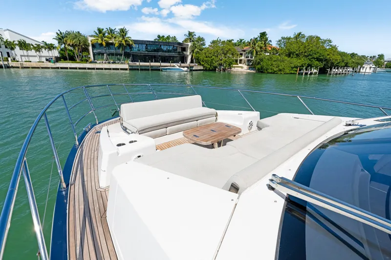 Slide: The Image of Luxurious Azimut 60 Fly yacht deck with seating, overlooking serene waterfront and lush greenery. - 52