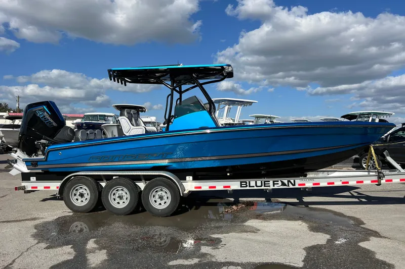Slide: The Image of 2025 Concept 27' Open Deck boat on trailer, vibrant blue, under a cloudy sky. - 16