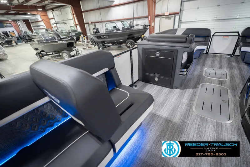 Slide: The Image of 2026 Bennington 24 MSL pontoon boat interior with modern seating and storage in showroom. - 29