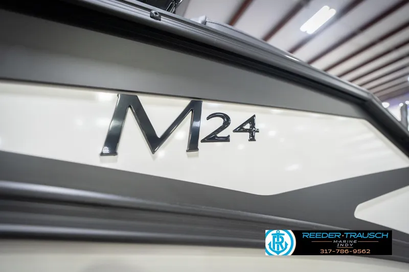 Slide: The Image of 2026 Bennington 24 MSL boat close-up with M24 logo, Reeder-Trausch Marine branding. - 57