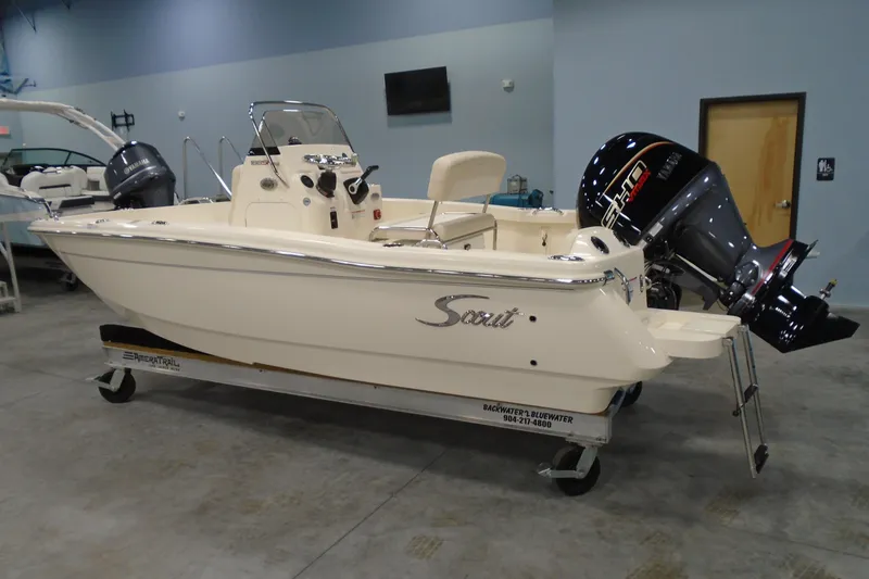 The Image of 2026 Scout 188 Sportfish boat in showroom, featuring sleek design and powerful engine. - 0