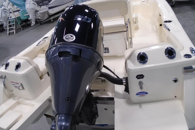 Slide: The Image of 2026 Scout 188 Sportfish boat with powerful outboard motor in showroom setting. - 18