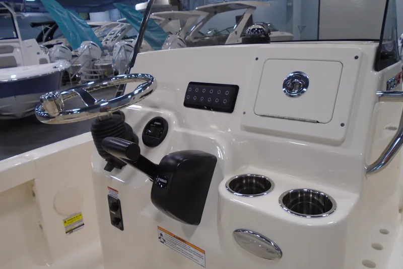 Slide: The Image of 2026 Scout 188 Sportfish boat console with steering wheel and cup holders. - 6