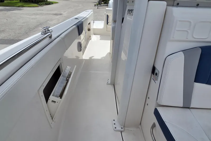 Slide: The Image of 2022 Robalo R272 Center Console boat interior with white and blue seating. - 12