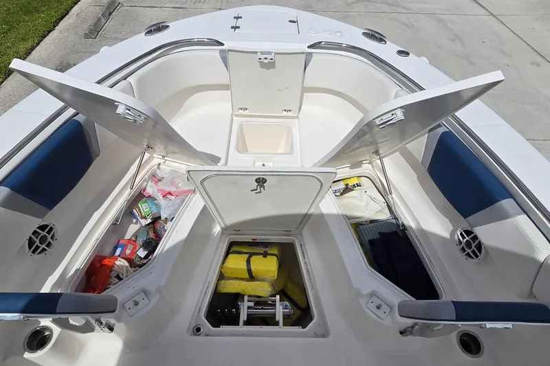 Slide: The Image of 2022 Robalo R272 Center Console boat with open storage compartments and safety gear. - 8