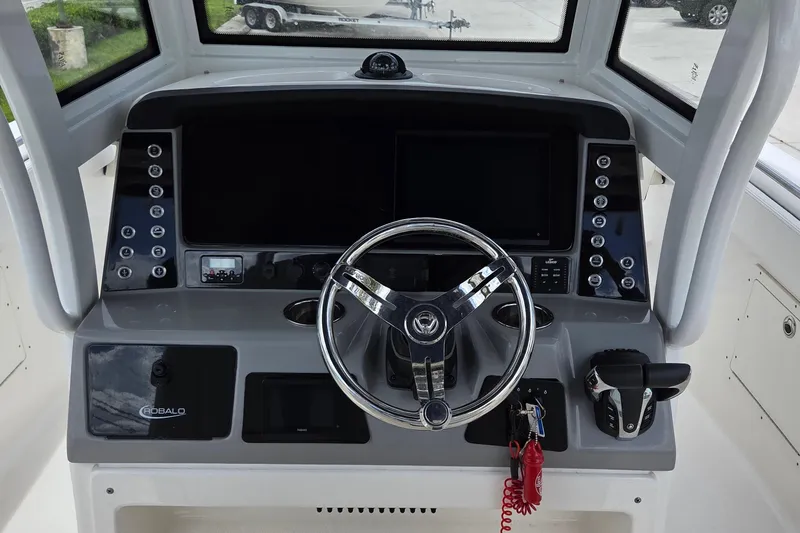 Slide: The Image of 2022 Robalo R272 Center Console helm with steering wheel and control panel. - 9