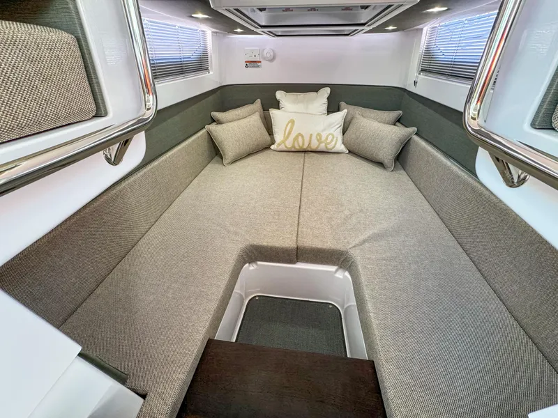 Slide: The Image of 2024 Axopar 37XC CROSS CABIN interior with cozy bedding and decorative pillows. - 22