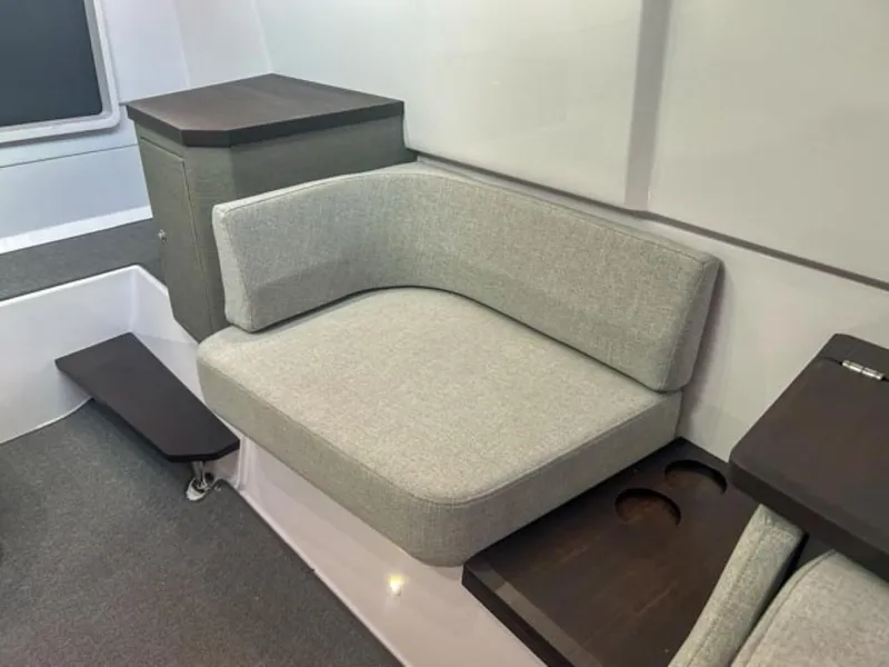 Slide: The Image of 2024 Axopar 37XC CROSS CABIN interior with gray seating and dark wood accents. - 16